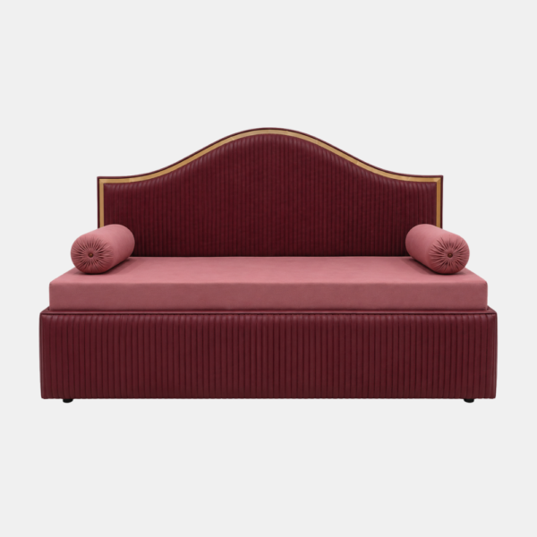 Blush velvet diwan cum bed in Dwarka with curved gold-trim headboard and pink bolster cushions on white background
