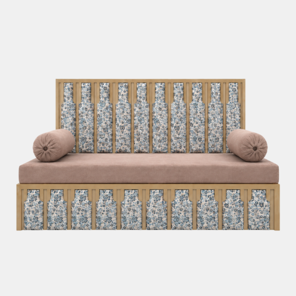 Ivory floral panel diwan bed in Rajouri Garden with gold frame and blush bolster cushions on white background