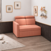 Rocco peach sofa cum bed displayed in a modern living room with wooden flooring, black wall panelling, decorative shelves, and framed artwork.