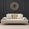 Amber cream sofa cum bed styled against a black decorative wall with golden accent legs